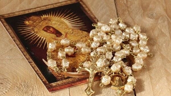 Ein wunderschönes eingerahmtes Bild der Muttergottes Maria sowie ein Rosenkranz mit einem goldenen Kruzifix
