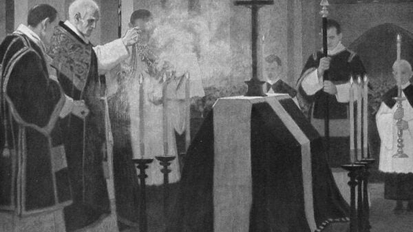 Totenmesse: Der Priester steht vor dem Sarg und inzensiert mit Weihrauch den Sarg.