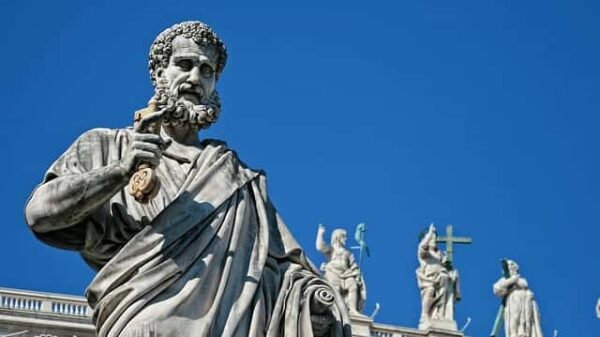 Statue von Petrus, dem ersten Papst, mit dem Schlüssel in der Hand, im Hintergrund der auferstandene Christus sowie zwei Heilige