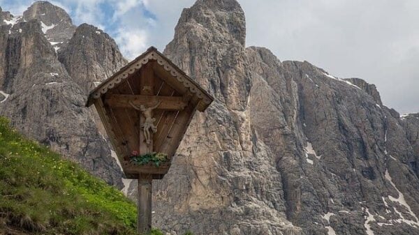 Ein Wegkreuz vor dem Hintergrund steiler Berge
